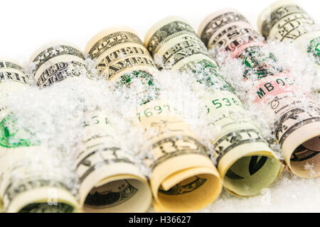 Dollaro americano rotoli di banconote in tutte le denominazioni coperte di neve Foto Stock