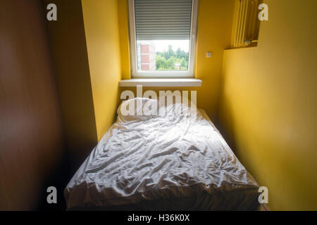 Crumpled biancheria bianca nel letto con metà finestra aperta dalla mattina Foto Stock