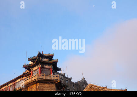 Una luna calante impostazione su un edificio cinese sul vertice del Taishan o Monte Tai nella provincia di Shandong la mattina presto li Foto Stock