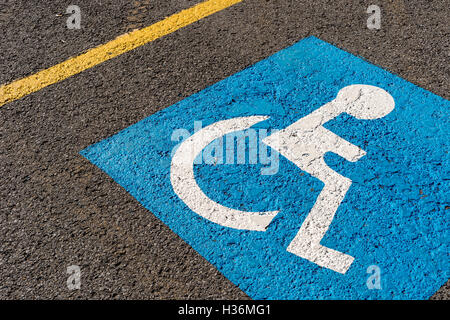 Disabili Parcheggio blu segno dipinto su asfalto scuro in Canada Foto Stock