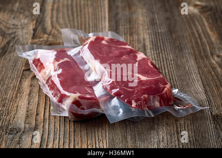 Carni bovine fresche bistecca per sous vide la cottura su un tavolo di legno Foto Stock