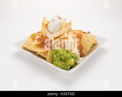 Nachos con queso, salsa guacamole e isolato su bianco Foto Stock