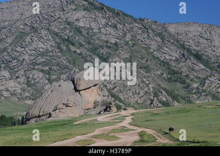 Un cavaliere solitario passa di Turtle Rock, Gorkhi-Terelj Parco Nazionale, Provincia Töv, Mongolia. © Kraig Lieb Foto Stock