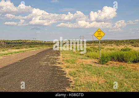 Area Rurale lungo il percorso 66 con un segno per un vicolo cieco in anticipo. Sembra che ci sia una porta al di là della strada. Foto Stock