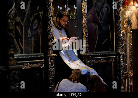 Una Chiesa Ortodossa Rumena sacerdote dà la benedizione per i credenti all'interno di San Antonio la Chiesa Ortodossa, conosciuta come la Chiesa dell'Annunciazione ( Biserica Sfantul Anton ) nella vecchia città di Bucarest, Romania Foto Stock