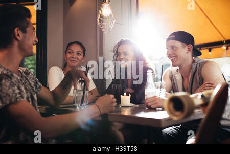 Gruppo di amici seduti in cafe e divertirsi. Gli adolescenti relax su coffee shop. Foto Stock