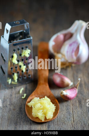 Aglio in cucchiaio su sfondo di legno Foto Stock