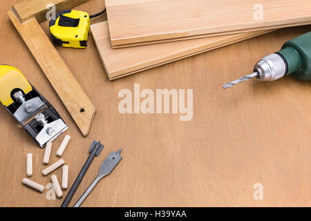 Falegname piano e un trapano con punta di plance su sfondo di legno Foto Stock