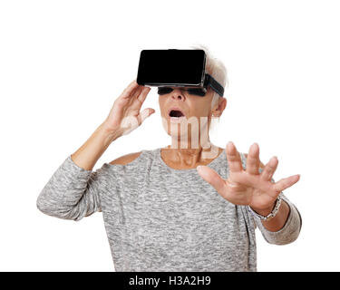 Senior donna con VR Virtual Reality auricolare è stordito Foto Stock