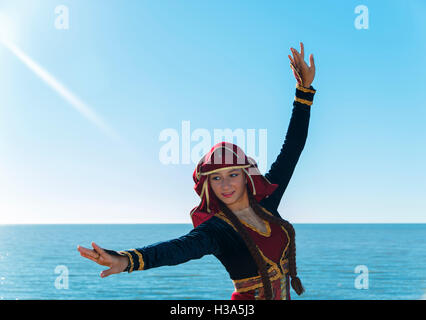 Giovane donna dancing georgian national vestiti all'aperto sul mare sole estivo Foto Stock