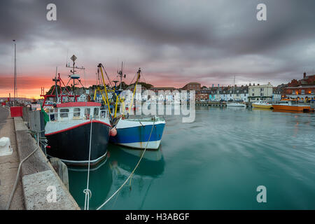 Un tempestoso tramonto sul porto di Weymouth su la costa del Dorset Foto Stock