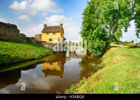 Un grazioso cottage thatched incorporata per i ruderi del castello di Stogursey in Somerset Foto Stock