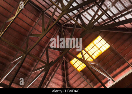 Costruzione interna del tetto in legno con travi e luminosa finestra spia Foto Stock