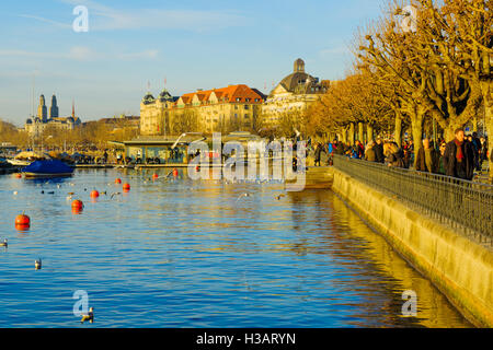 ZURICH, Svizzera - 27 dicembre 2015: Tramonto scena presso la banca del lago di Zurigo, con la gente del posto e i turisti e la città vecchia a Foto Stock