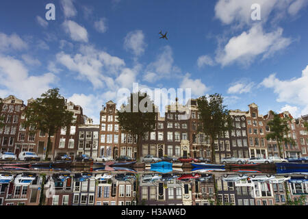 L'aereo oltre le tradizionali case olandese riflessa nell'acqua, immagine capovolta, Amsterdam Foto Stock