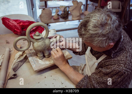 Coppia potter carving su argilla elephant Foto Stock