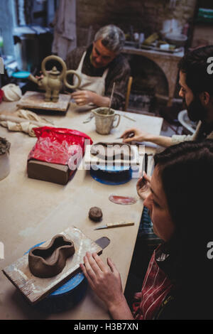 Concentrato potters lavorando a tavola Foto Stock