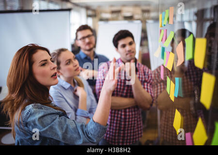 Bella imprenditrice guardando sticky notes Foto Stock