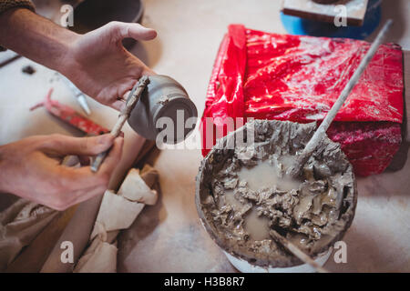 Immagine ritagliata di potter tenendo la coppa in ceramica Foto Stock