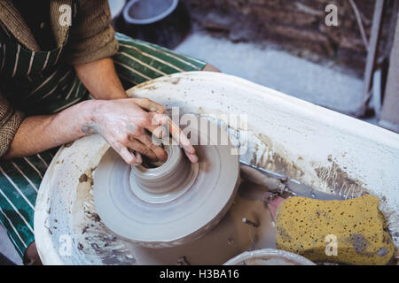Artigiano rendendo il contenitore in officina del potter Foto Stock