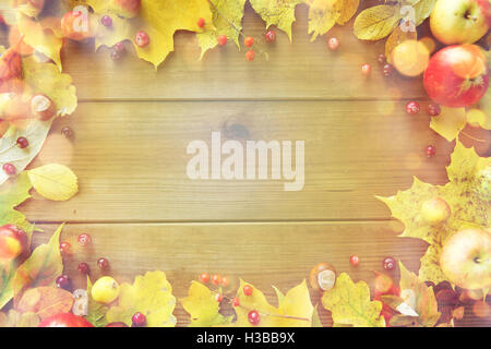 Telaio di foglie di autunno, frutti e bacche su legno Foto Stock