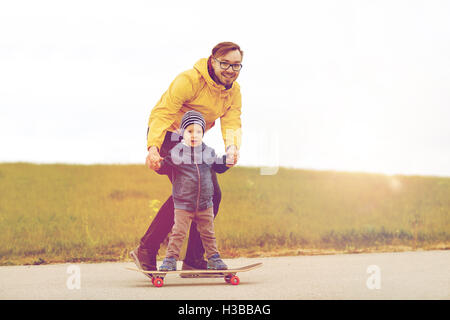 Felice padre e figlio su skateboard Foto Stock