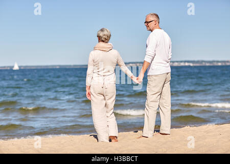 Felice coppia senior holding hands estate spiaggia Foto Stock