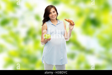 Felice donna incinta con Apple e croissant Foto Stock