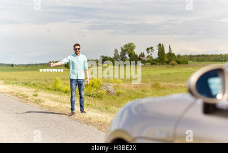 L'uomo autostop e arresto di auto in campagna Foto Stock