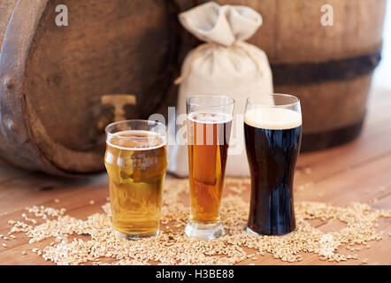 Chiusura del barile di birra, occhiali ed il sacchetto con malto Foto Stock