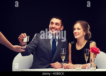 Coppia sorridente pagando per la cena con carta di credito Foto Stock