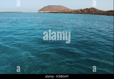 Fuerteventura Isole Canarie Nord Africa: acqua cristallina e la caldera mountain (La Caldera), il vulcano della piccola isola di Lobos Foto Stock