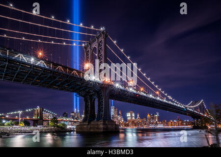 Il tributo alla luce e la Freedom Tower incorniciato da Manhattan Bridge. Un impressionante solenne memoriale per ricordare le vittime Foto Stock