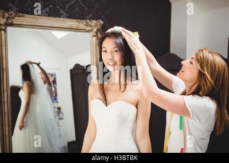 Donna cercando in abito da sposa con il contributo di designer creativo Foto Stock