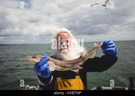 Ritratto di pescatore di pesci di contenimento Foto Stock