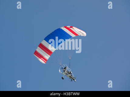 Powered parapendio volando sotto il cielo blu chiaro Foto Stock