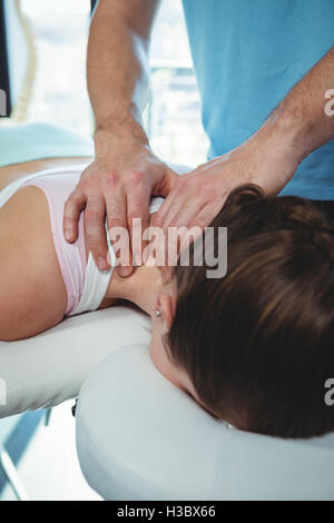 Fisioterapista dando la terapia fisica per il collo di un paziente di sesso femminile Foto Stock