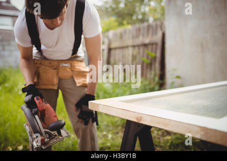 Carpenter lavora con sega circolare Foto Stock