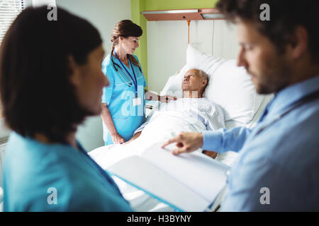 L'infermiera consolante paziente senior Foto Stock