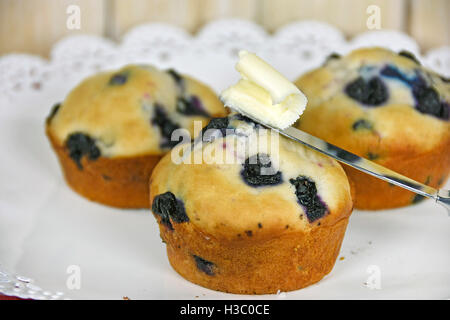 Close up in casa muffin ai mirtilli con burro sul coltello Foto Stock