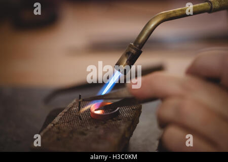 Artigianato orafo anello mediante bruciatore Foto Stock