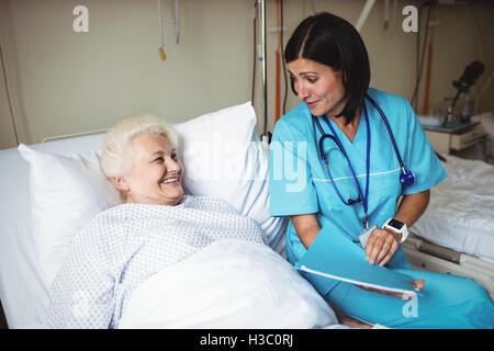 L'infermiera che interagisce con il paziente senior Foto Stock