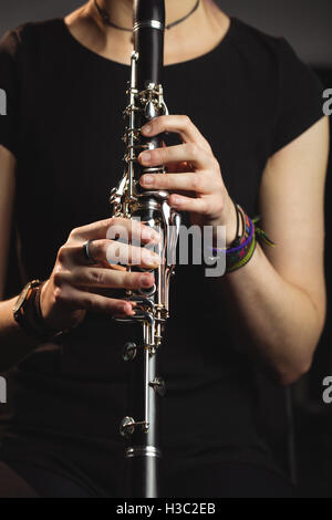 Donna che gioca un clarinetto nella scuola di musica Foto Stock