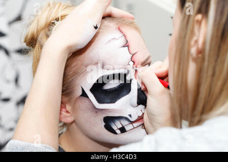 Bellissima ragazza con la faccia arte su Halloween, in bianco e nero cranio Foto Stock