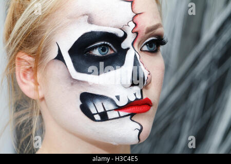 Bellissima ragazza con la faccia arte su Halloween, in bianco e nero cranio Foto Stock