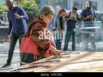 Una donna anziana sta guardando ad un tablet iPad in un Apple store sull'Upper West Side di Manhattan. Foto Stock