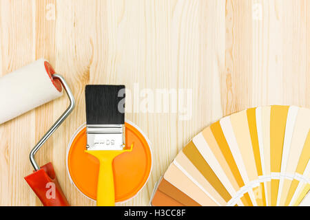 Spazzola a rullo e con guida a colori e la vernice può su sfondo di legno Foto Stock