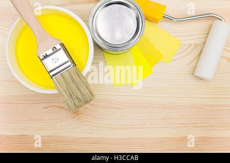 Spazzola a rullo e con i campioni di colore e di vernice può su sfondo di legno Foto Stock