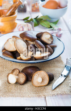 Re tromba di funghi e gli ingredienti per cucinare sul tavolo della cucina Foto Stock