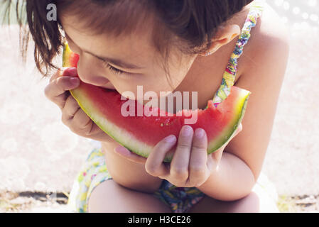 Ragazza mangiando anguria, close-up Foto Stock